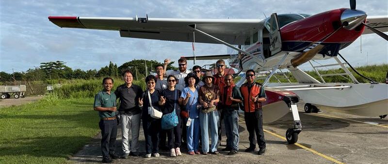 Participants stand in front of plane