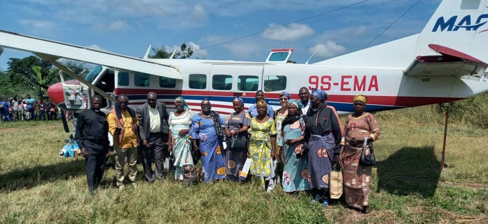 Participants stand in front of plane